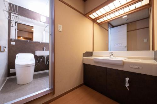un bagno con lavandino, water e specchio di Ohanabo a Kyoto
