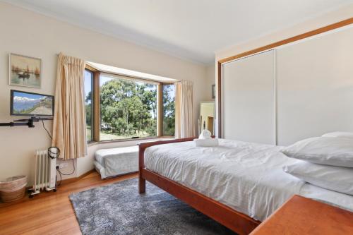 a bedroom with a large bed and a large window at Halcyon in Nungurner