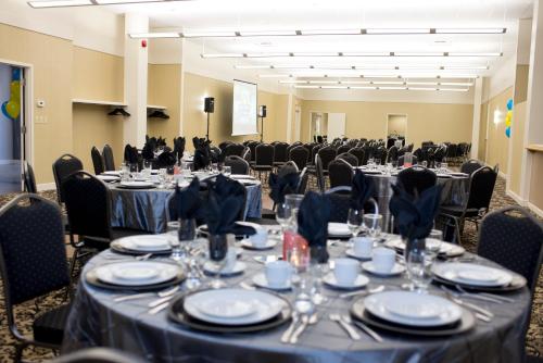 a conference room with tables and chairs with blue table linens at Days Inn & Suites by Wyndham Sault Ste. Marie ON in Sault Ste. Marie