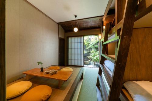 金沢市にあるSAIK 西玖のベッド2台、テーブル(枕付)が備わる客室です。