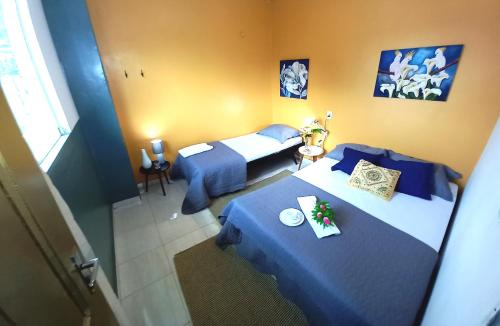 Habitación de hotel con 2 camas con sábanas azules en Hostel e Pousada Chez Luisa - Salvaterra - Marajó, en Salvaterra