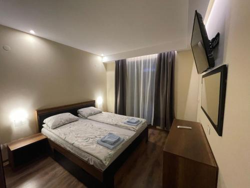 a small bedroom with a bed and a window at Grand Bansko 1 Family apartment B206 in Bansko