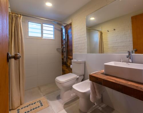 a bathroom with a toilet and a sink and a mirror at Alma Serena in La Paloma