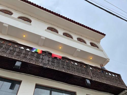 a white building with flags on the balcony at TATA Hotel Boutique in Cusco
