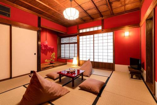 a living room with red walls and a table at Saik in Kanazawa