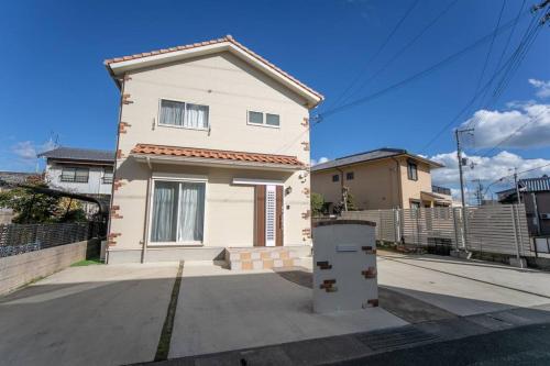 a white house with a fence in front of it at Shizukinosato TSUKI Terrace 531 in Awaji