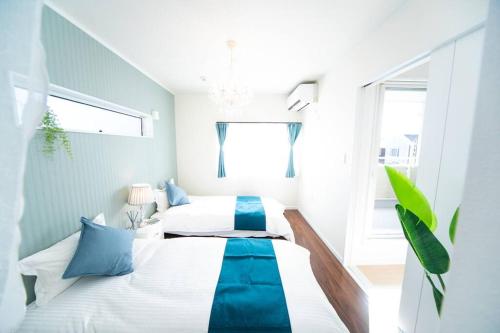 a bedroom with two beds with blue and white sheets at Shizukinosato TSUKI Terrace 531 in Awaji