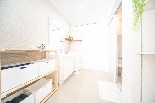 a kitchen with white cabinets and a white floor at Shizukinosato TSUKI Terrace 531 in Awaji