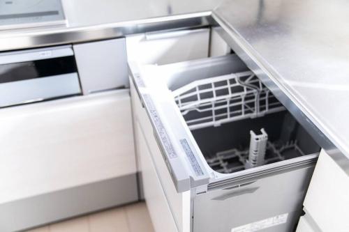 an empty dishwasher in a kitchen with its door open at Shizukinosato TSUKI Terrace 531 in Awaji