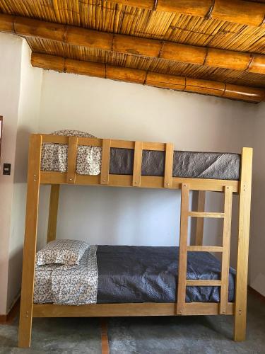 two bunk beds in a room with a ceiling at Las Cabañas de Incahuasi in Lunahuaná