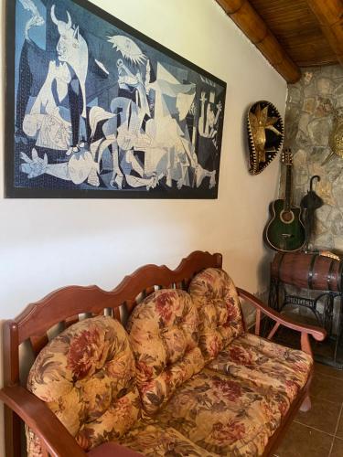 a couch in a living room with a painting on the wall at Las Cabañas de Incahuasi in Lunahuaná