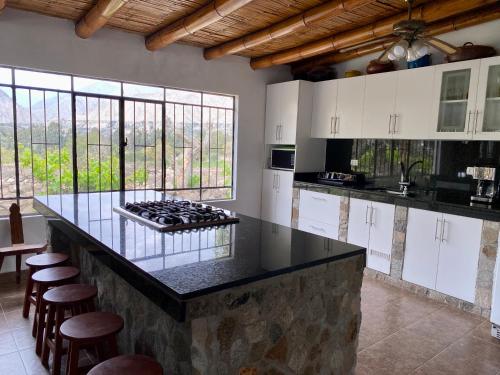 a kitchen with a counter with a stove in it at Las Cabañas de Incahuasi in Lunahuaná