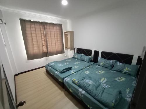 een slaapkamer met een bed en een raam bij Sunny Homestay Kuching - LANDED 14 PAX in Kuching