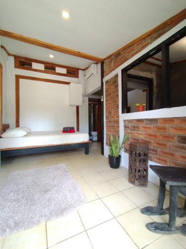 a room with a bed and a brick wall at VILLA OPA DOEL YOGYAKARTA in Yogyakarta