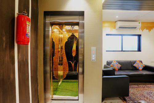 a living room with a couch and a glass door at FabHotel Prime Land - Nr BKC in Mumbai