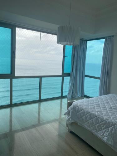 1 dormitorio con cama y vistas al océano en Vista al mar Habitación Privada Coral en Malecon Santo Domingo 1-829-343-1001, en Santo Domingo