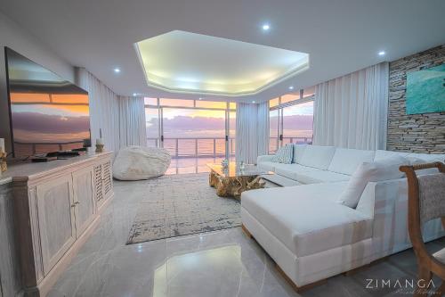 sala de estar con sofá blanco y mesa en Beachfront Penthouse Ballito, en Ballito