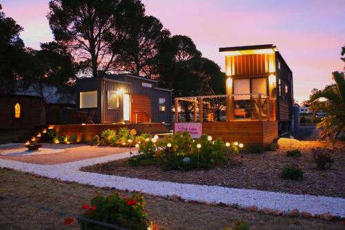 a tiny house with lights in a garden at night at Pink Lake Tiny House - 'Peony' in Lochiel