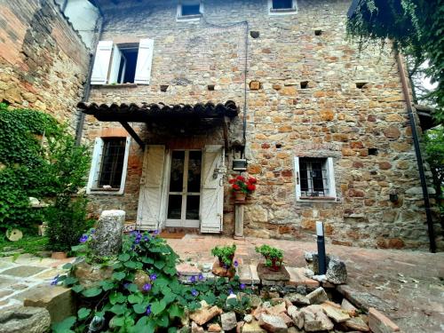 Montalbo的住宿－Casa Morelli，一座古老的石头房子,前面有鲜花