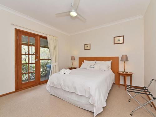 a bedroom with a white bed and a window at La Sila Homestead on Marrowbone in Mount View