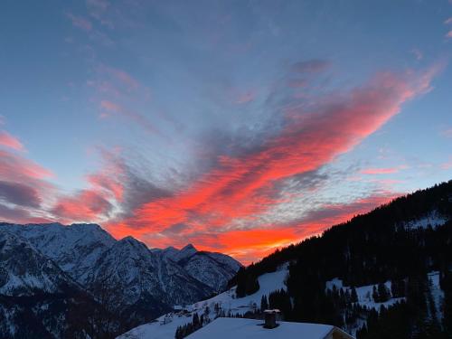 a sunset over a snow covered mountain range at Southern Stables Ranch in Bannberg
