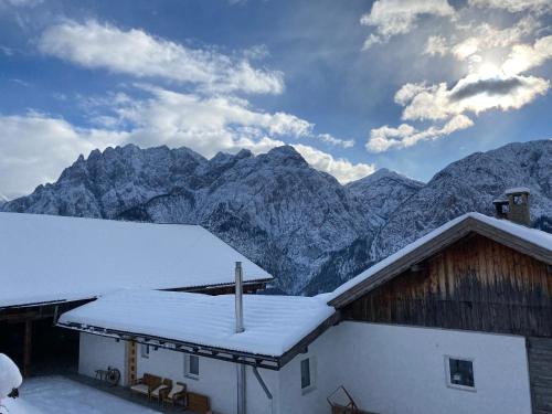 a snow covered building with mountains in the background at Southern Stables Ranch in Bannberg