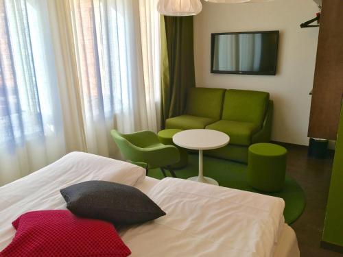 a bedroom with a bed and a couch and a table at Best Western Hotel Akersberga in Åkersberga
