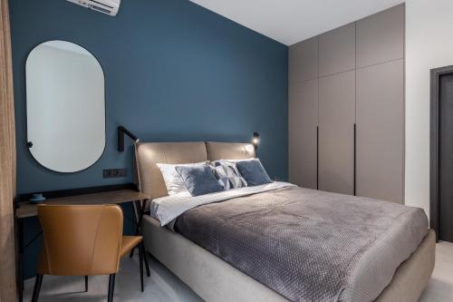 1 dormitorio con paredes azules, 1 cama y 1 silla en Old City FORUM Apartments en Leópolis