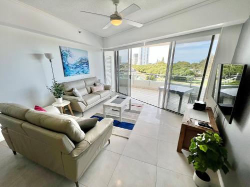 a living room with a couch and a tv at Sebel 302 - Deluxe Apartment in Maroochydore