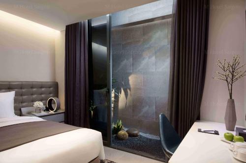 a bedroom with a bed and a glass wall at M Hotel Saigon in Ho Chi Minh City