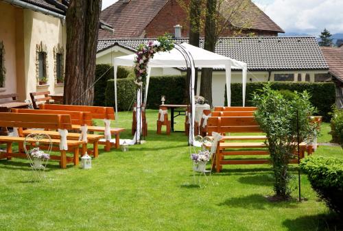 an outdoor ceremony with benches and a gazebo at Penzion za mlynom in Bešeňová