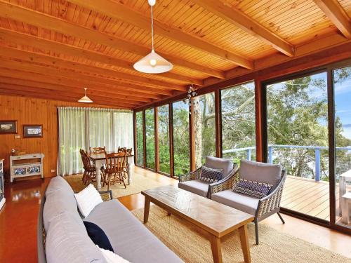 a living room with a couch and chairs and a table at Wangi Waterfront HIdeaway in Wangi Wangi