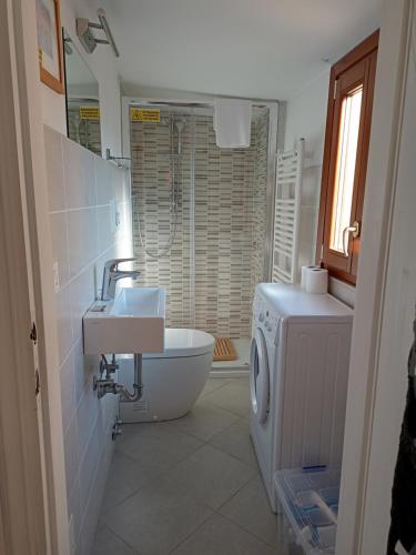La salle de bains est pourvue d'un lavabo et d'un lave-linge. dans l'établissement LA GUGLIA - Guglia House-CANNAREGIO-VENEZIA, à Venise