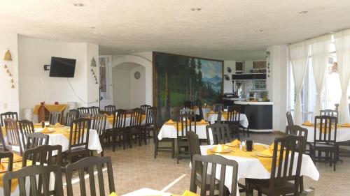 a dining room with tables and chairs in a restaurant at Hotel Villa Monarca Inn in Zitácuaro