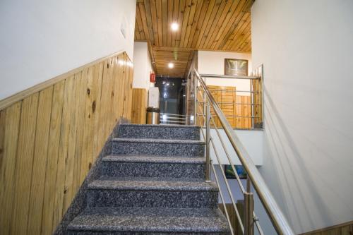 a staircase leading up to a building with wooden ceilings at Vella Marina Group of Hotels Mount-Hotels Best Prices Guaranteed with Deals- Free Parking-cricket stadium 10 km-Mcleodganj 2 km- Bhagsunag 4 km in Dharamshala