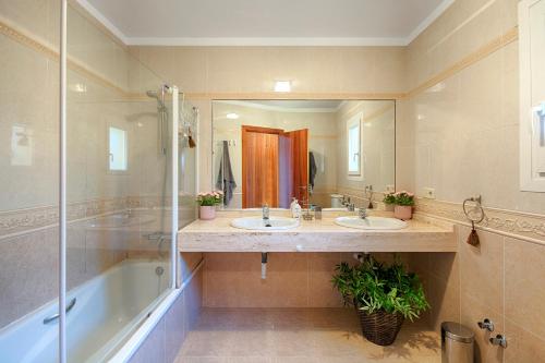 a bathroom with two sinks and a tub and a mirror at Casa Albera - with pool and fantastic views in Palau-Saverdera