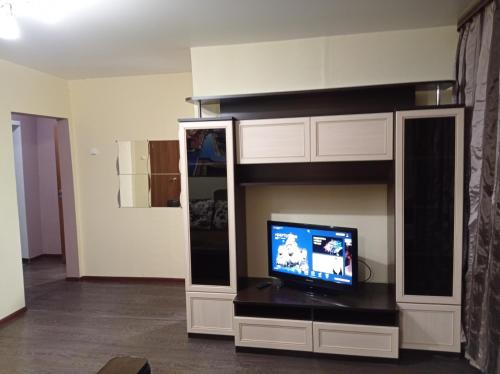 a living room with a tv in a entertainment center at 2к. Апартаменты НСК,на ул. Блюхера 6 in Novosibirsk