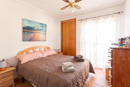 - une chambre avec un lit et un ventilateur de plafond dans l'établissement Pool-side townhouse in Cabo Roig, à Orihuela