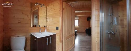 y baño de madera con lavabo y ducha. en Cabañas Madarsu, en Vigo de Sanabria