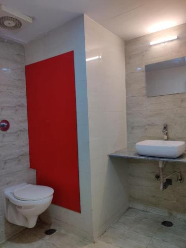 a bathroom with a toilet and a sink at Hotel Chetan International in Bengaluru