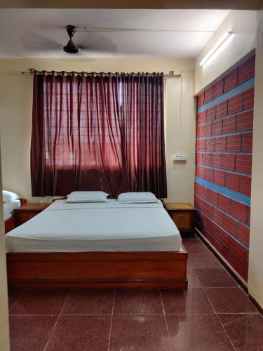 a bedroom with a bed and a red window at Hotel Chetan International in Bengaluru