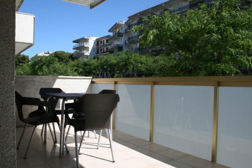 a balcony with black chairs and a table on a fence at Suite Apartments Arquus in Salou