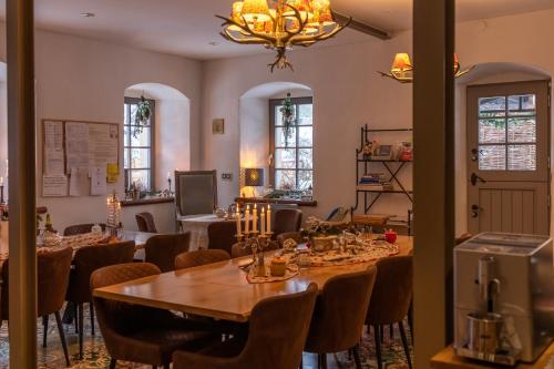 a dining room with tables and chairs and a chandelier at Holzwerk Oybin in Kurort Oybin