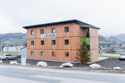 ein großes Holzgebäude mit einem Schild darauf in der Unterkunft Motel XL Lounge in Traisen