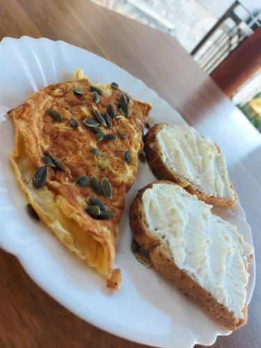 a white plate with two pieces of food on it at Guest House Godimento in Čilipi