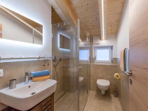 a bathroom with a sink and a shower and a toilet at Appartement Morgensonne in Westendorf