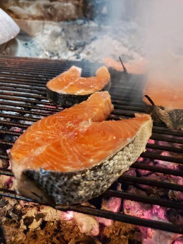 two pieces of fish cooking on a grill at Guest House Godimento in Čilipi