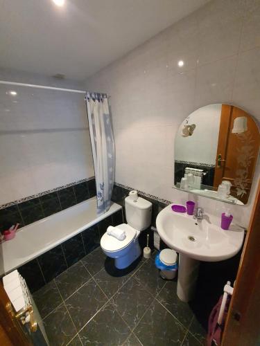 a bathroom with a sink and a toilet and a mirror at Pension A Barca in O Barco de Valdeorras