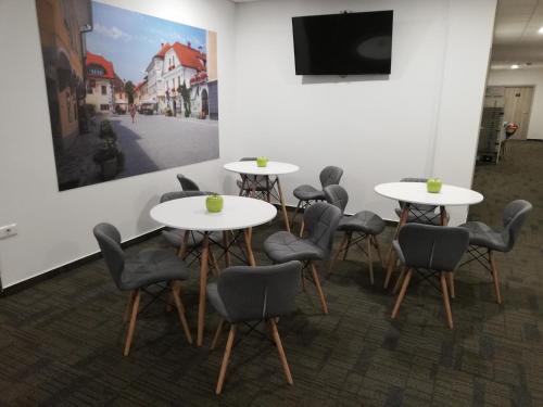 a group of tables and chairs in a room at Life Hostel Slovenia in Radovljica