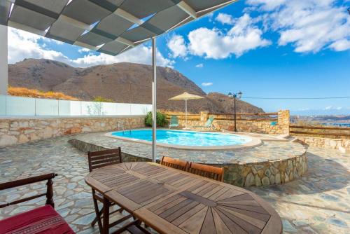 a patio with a table and a swimming pool at Villa Konstantina in Exopoli